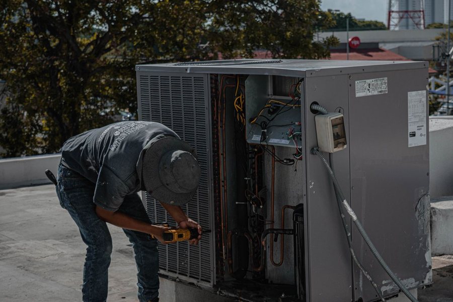 Kenyon & Sons technician servicing a rooftop HVAC condenser unit