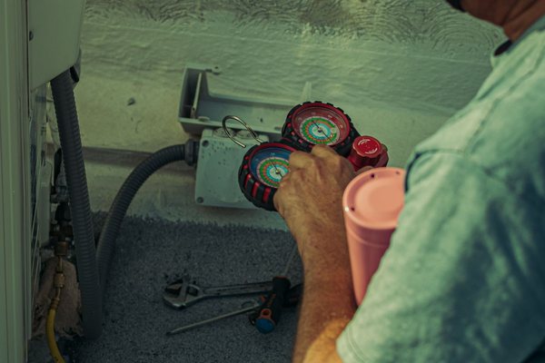 Technician with HVAC refrigerant gauges
