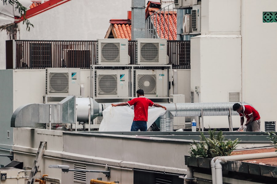 Technicians servicing rooftop commercial air-conditioning units